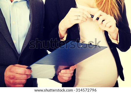 Working pregnant woman signing contract with her partner
