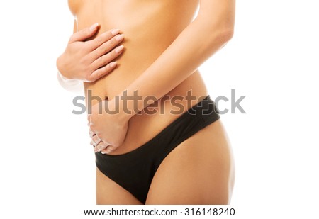 Tanned woman touching her slim belly.