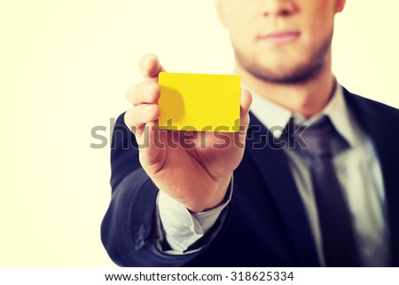 Handsome businessman showing his yellow personal card.
