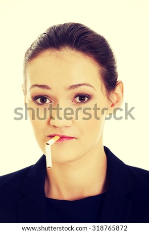 Beautiful businesswoman with broke cigarette in mouth.