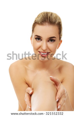 Young smiled woman touching her leg, isolated on white