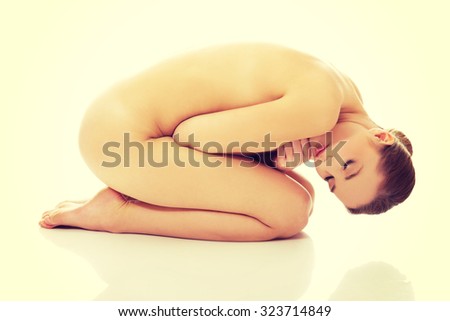 Young beautiful spa woman curled up on the floor.