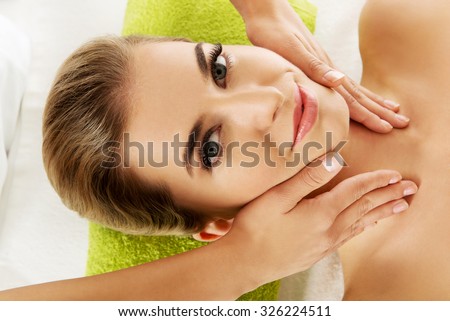 Young smile relaxed woman is massaged on massaged table.