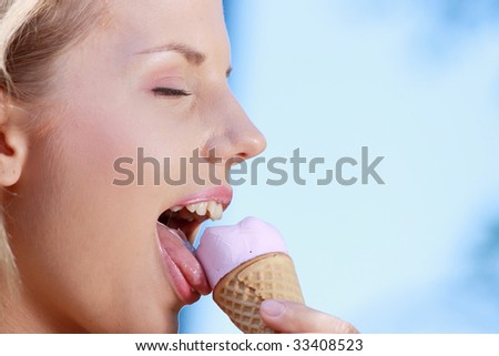 Portrait of young happy woman eating ice-cream, outdoor