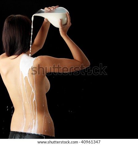 Young beautiful woman with milk, isolated on black. Skin care concept