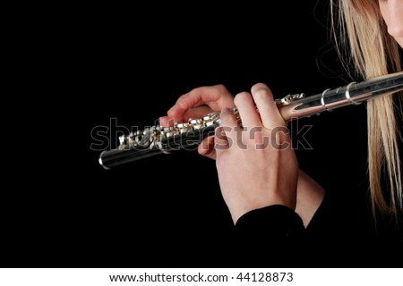 Portrait of a woman playing transverse flute, isolated on black