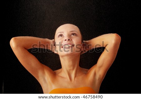 Close-up of beautiful happy wet woman face with water drop. Isolated on black background