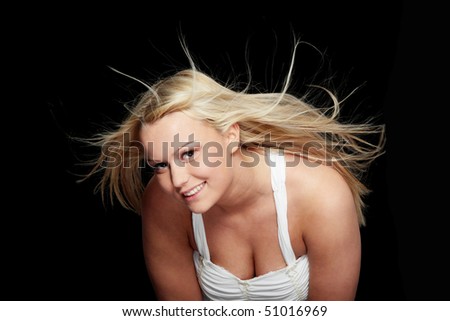 Young beautiful woman in  white dress and wind in her hairs (hair blowing), isolated on black background.