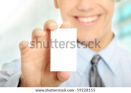Young happy smiling successful business man with blank business card or sign