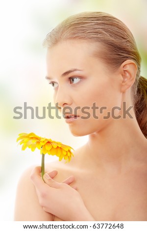 Portrait of the attractive girl without a make-up, with flower in hand