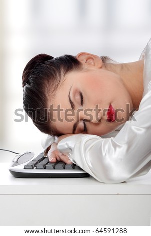 Young businesswoman sleeping on the keyboard in the office.