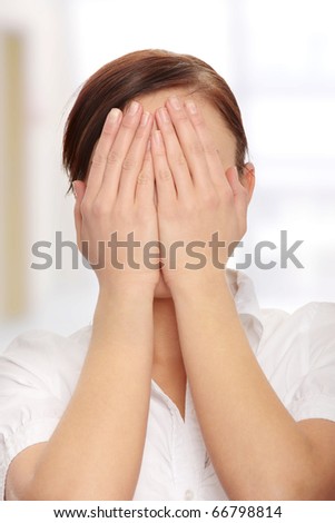 Troubled business woman covering her face with hands