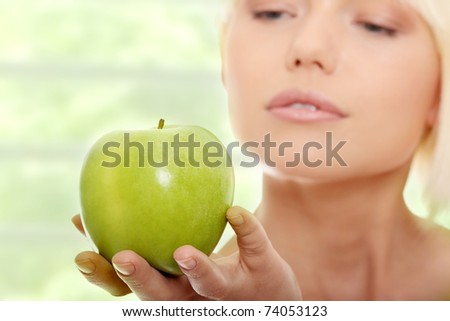 Beautiful blond woman with green apple