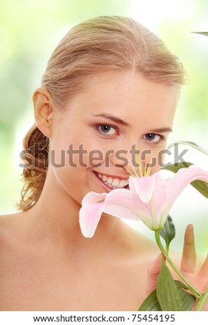 Portrait of the attractive girl without a make-up, with lily flower in hand
