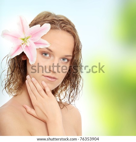 Portrait of the attractive woman without a make-up, with lily flower in hand.