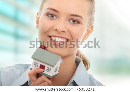 Young beautiful business woman with house model - real estate