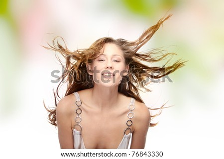 Young beautiful woman in elegant, evening, white dress dancing with wind (hair blowing).