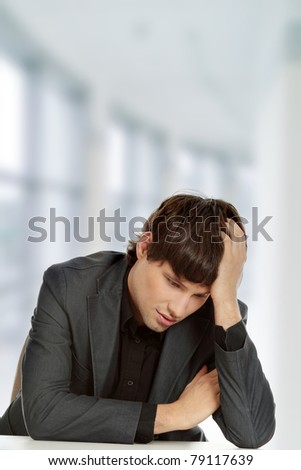 Businessman in depression, with hand on forehead.