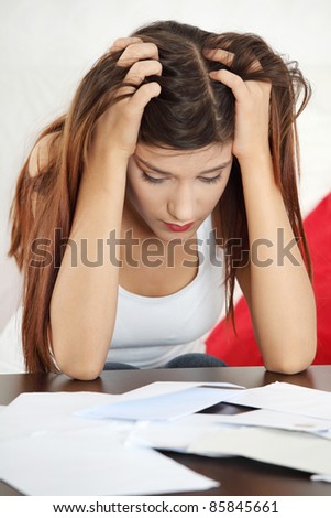 A young beautiful woman stressed because of bills.