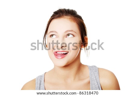 Portrait of teen girl licking her lips and looking on upper left corner.