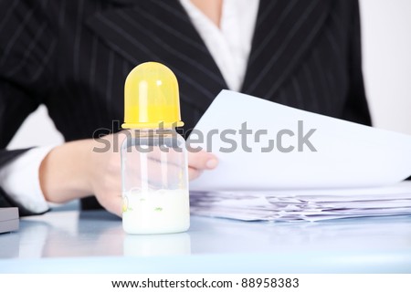 Baby bottle with milk in the office.