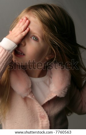 Little girl covering eye