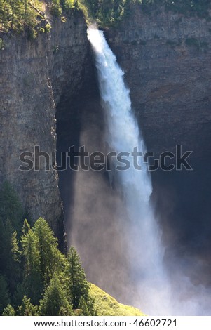 A large waterfall falls down among steel cliffs. Helmcken Falls, Wells Gray Park, Canada.