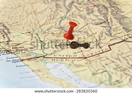 Phoenix Arizona marked on map with red pushpin. Selective focus on the word Phoenix and the pushpin. Pin is in an angle and casts some shadow to the right.