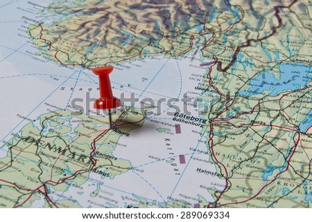 Alborg marked with red pushpin on map. Selected focus on Alborg and bright red pushpin. Pushpin is in an angle. Southern parts of Sweden and Norway can be seen on map.