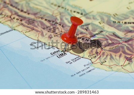 Lima marked on map with red pushpin. Selective focus on the word Lima and the pushpin. Pin is in an angle and casts some shadow to the right.