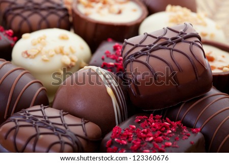 An assortment of fine chocolates in white, dark, and milk chocolate. - stock photo