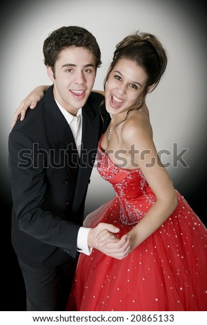 Boy & girl, in formal attire, dancing at their high school prom.