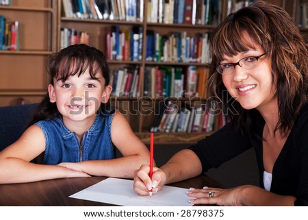 A happy child learning spelling from her tutor.