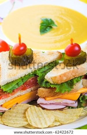 A delicious clubhouse sandwich, served with crunchy rippled potato chips and creamy butternut squash soup.