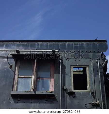 black side of an abandoned rail car featuring door and window