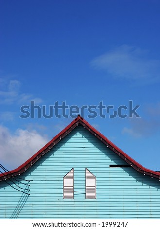 Bright green house against a deep blue sky