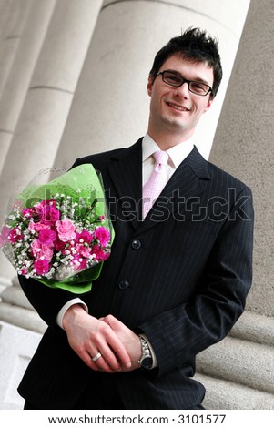 Attractive young man has pink bouquet of flowers for his girlfriend.