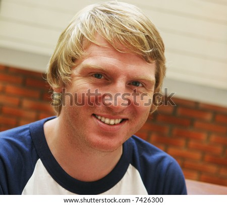 Portrait of an attractive blond man smiling.
