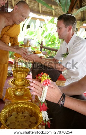 KOH LANTA - DECEMBER 2: Western couple gets married during a traditional Buddhist wedding on December 2, 2008 in Koh Lanta, Thailand.
