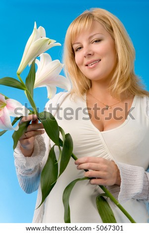 the pregnant woman with madonna lily on blue background