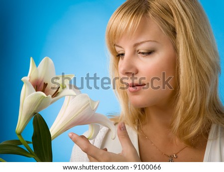 young blond woman with madonna lily on blue background