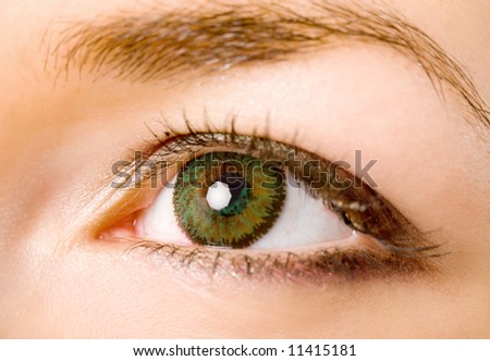 female eye with green contact lenses macro