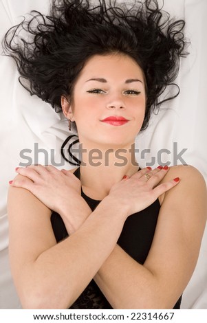 The beautiful woman lies on a white bed-sheet