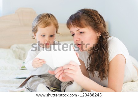 Cute boy with his mother playing with paper cards