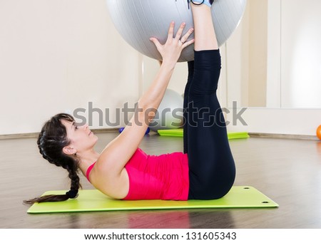 Pretty young woman fitness workout in gym with fitball