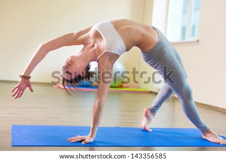 Beautiful young woman yoga workout in gym