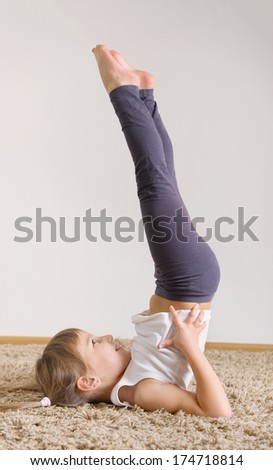 Cute little girl yoga exercising at home