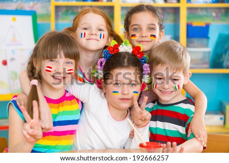 Happy children in language camp with flags on cheeks