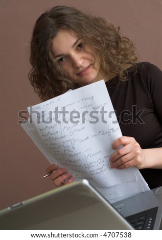 Pretty student is holding papers in hands, penetrating glance