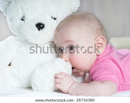 Little baby is playing with teddy bear